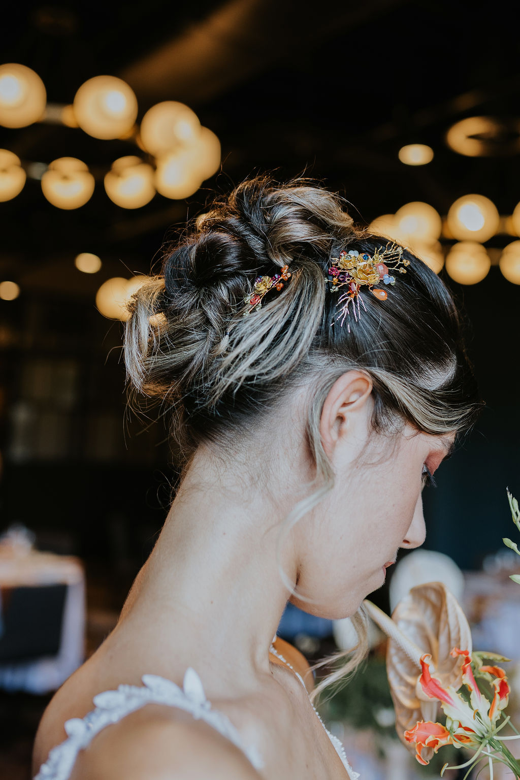 Bridal updo adorned with a delicate Hermione Harbutt hair accessory, styled in a soft, twisted 90s-inspired look