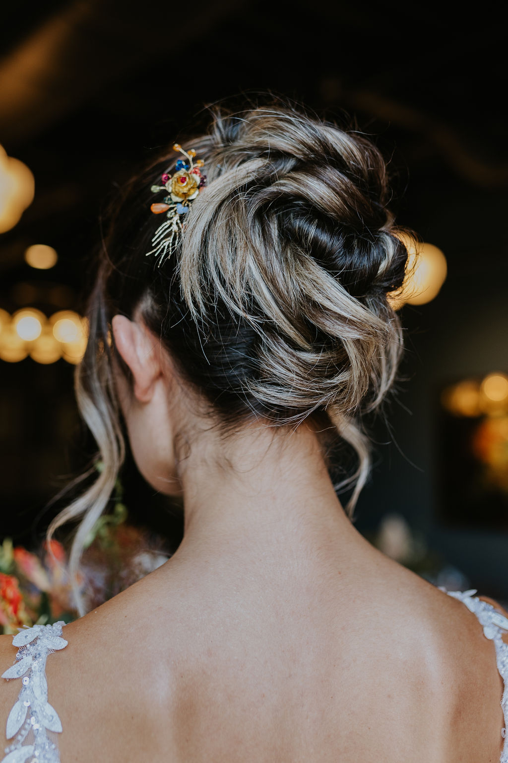 Bridal hairstyle with a soft, 90s-inspired updo featuring a modern Pammy twist and loose, elegant texture