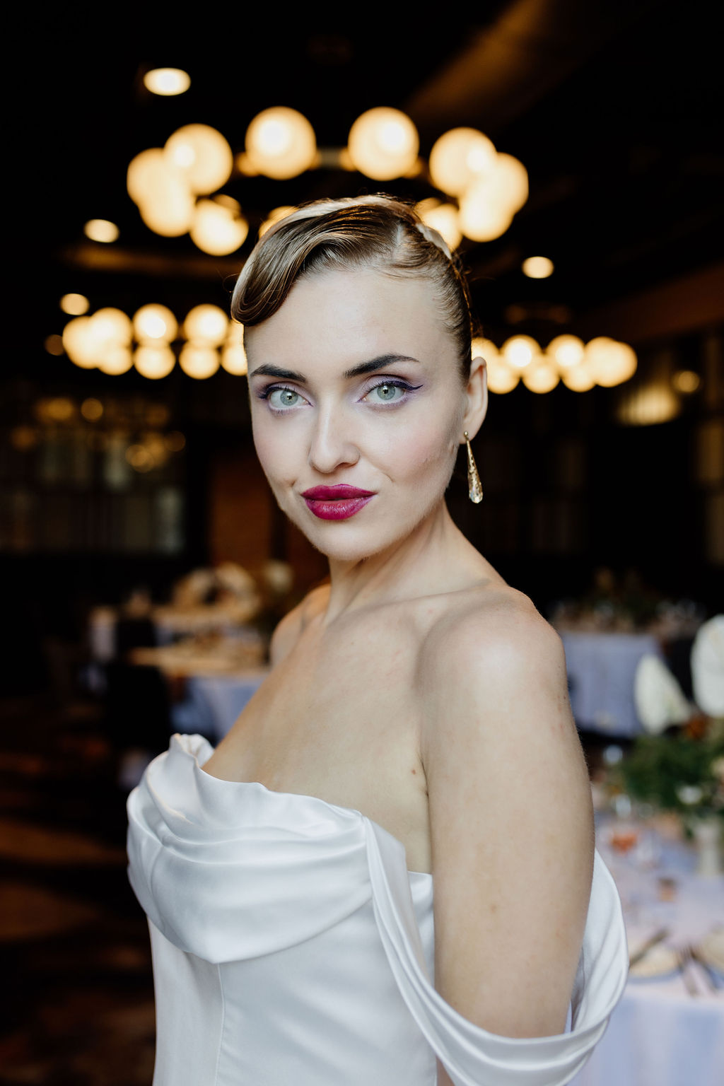 Bride laughing naturally with fresh glowing skin and bold lipstick in a candid bridal beauty moment