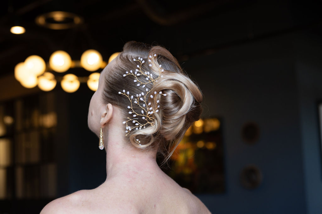 Side profile of bride with vintage-inspired waves and modern bridal makeup, including winged eyeliner and dewy skin